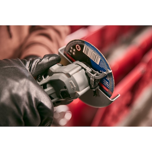 STANLEY STA32637 photography of gloved hand holding angle grinder with abrasive disc in close-up view.