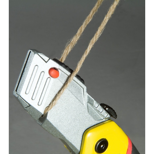 Photo of STANLEY 10-825 utility knife cutting brown twine, close-up angle showing yellow handle.