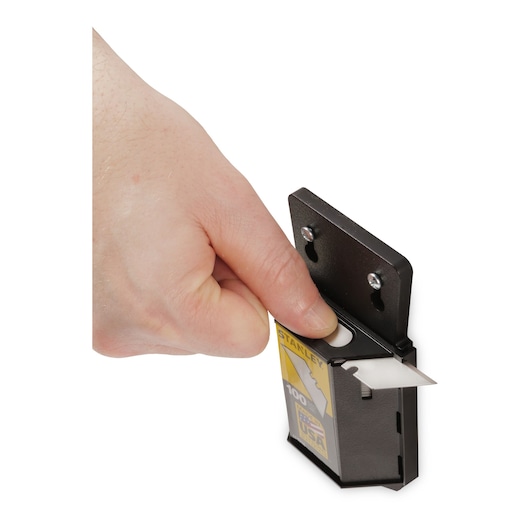 STANLEY 11-921A utility blade dispenser with hand extracting a blade, close-up on white background.