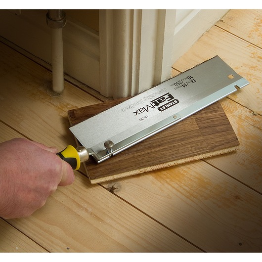 STANLEY 15-252K flush cut saw cutting laminate flooring near wall, close-up angle.