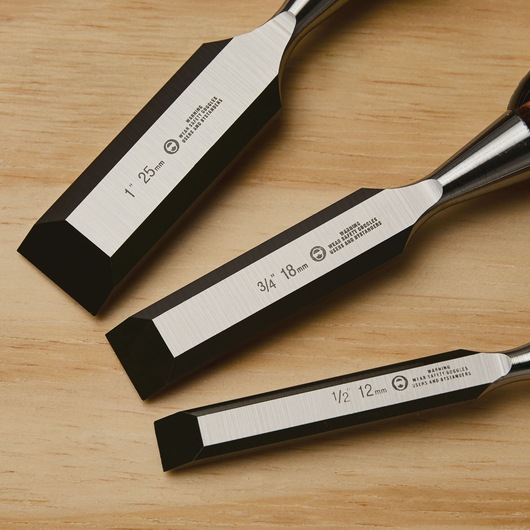 STANLEY 16-970 set of three wood chisels with beveled edges, shown on wood surface, close-up view.
