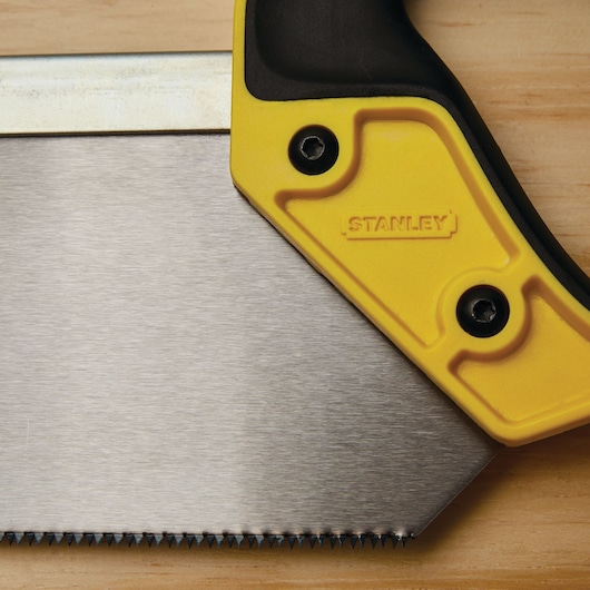 STANLEY 17-202 hand saw close-up showing yellow handle and silver blade on wood surface.