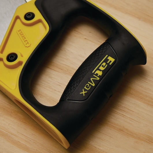 STANLEY FatMax 17-202 saw handle close-up, black and yellow grip with textured surface on wood background.