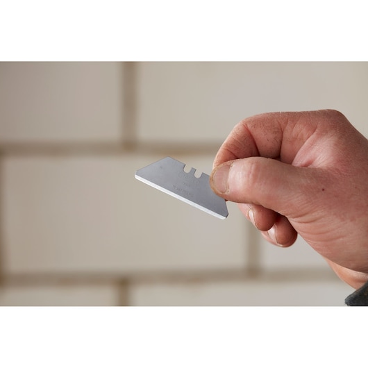 Photo of STANLEY 2-11-987 utility blade held in hand, silver color, close-up view.