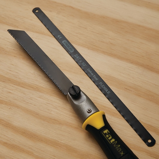 STANLEY 20-220 hand saw with black and yellow handle and an extra flexible blade on wood surface.