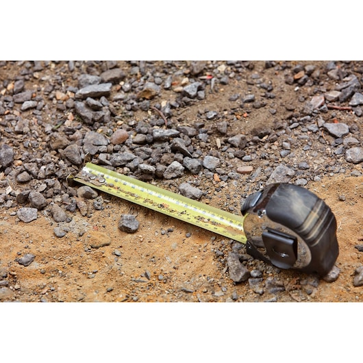 STANLEY 33-894 tape measure on gravel and dirt, extended measuring blade visible.