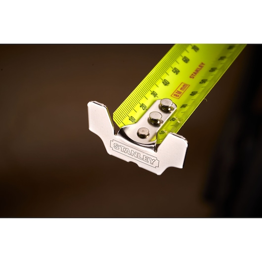 Stanley 33-894 tape measure close-up, showing yellow blade and metal hook in photography.