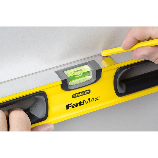 Stanley 43-524 FatMax level used for drawing a straight line on a wall, close-up photography.