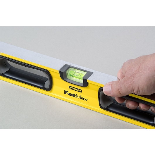 Photo of STANLEY 43-524 FatMax spirit level held in hand, yellow body with black handles and visible vial.