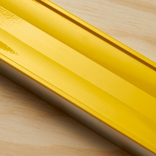 STANLEY 43-548 yellow aluminum level photographed diagonally on a light wooden surface.