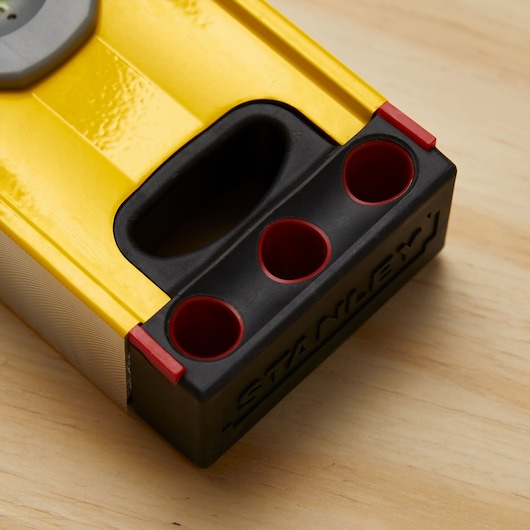 STANLEY 43-548 yellow and black photography level with three red-edged holes, close-up on wood surface.