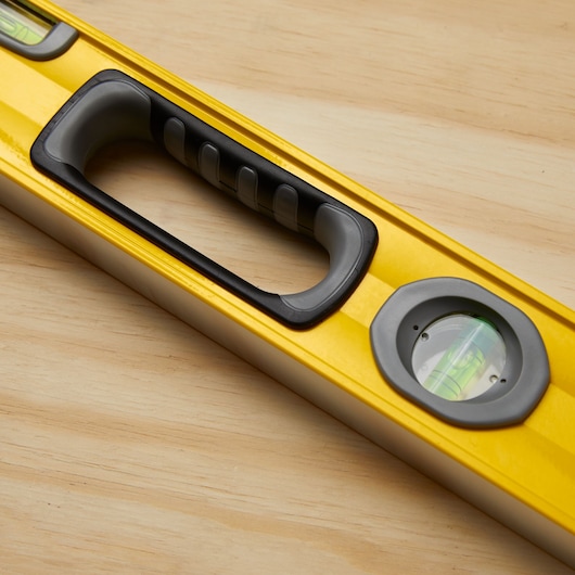 STANLEY 43-548 yellow level tool with handle and bubble vial, close-up on wood surface.
