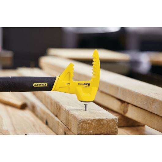STANLEY 55-119 FatMax claw bar tool in yellow and black, shown on wooden planks in a workshop.