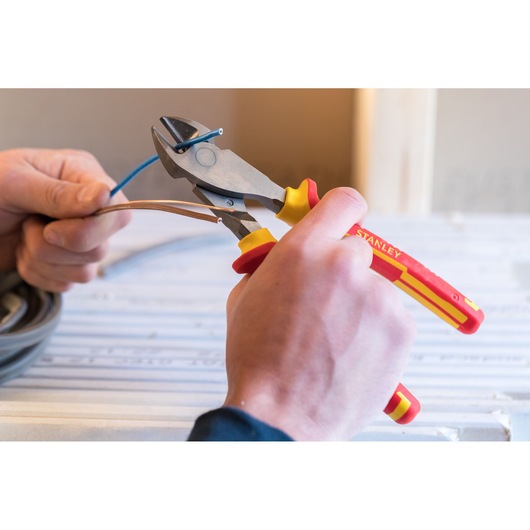 STANLEY 84-004-S insulated wire cutter with red and yellow handle, close-up in use cutting cables.