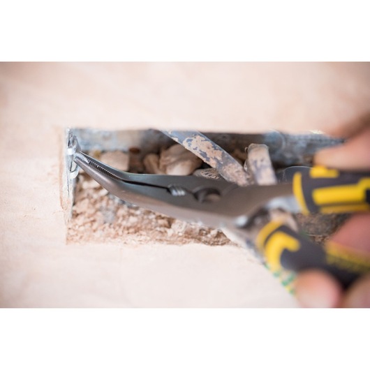 STANLEY 89-872 pliers, close-up angle, gripping screw in electrical box, black and yellow handle.