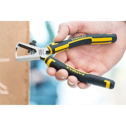 Photo of STANLEY 89-873 wire stripper pliers with black and yellow handles, held in hand.