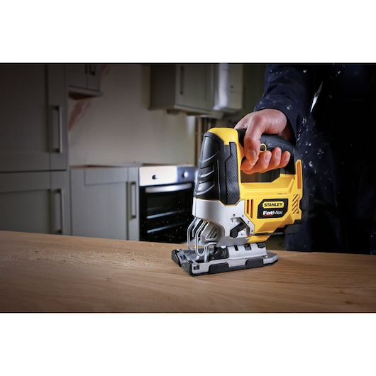 STANLEY FME340K jigsaw power tool in use on wood, close-up angle, yellow and black design.