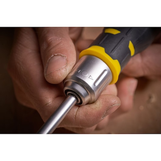 Photo of STANLEY FMHT0-62690 screwdriver handle with yellow and black grip, close-up in a hand.