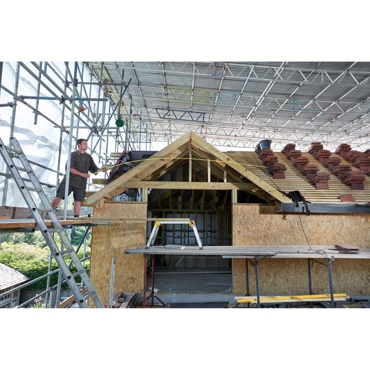 STANLEY FMHT36328 photography of saw horse on construction site with scaffolding and unfinished roof.