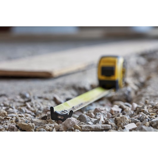 STANLEY FMHT36328 tape measure photography on rocky construction surface.