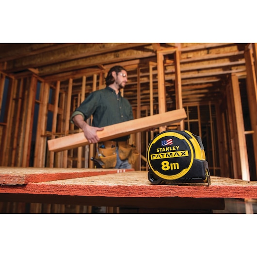 STANLEY FMHT36328 FATMAX 8m tape measure photography on construction site foreground.
