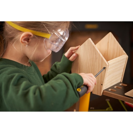 Photo of STANLEY K020-SY screwdriver in use assembling a wooden box, close-up, product held by a child.