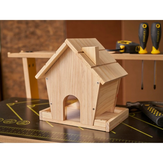 STANLEY K020-SY wooden birdhouse on workbench, surrounded by STANLEY screwdrivers and measuring tape.