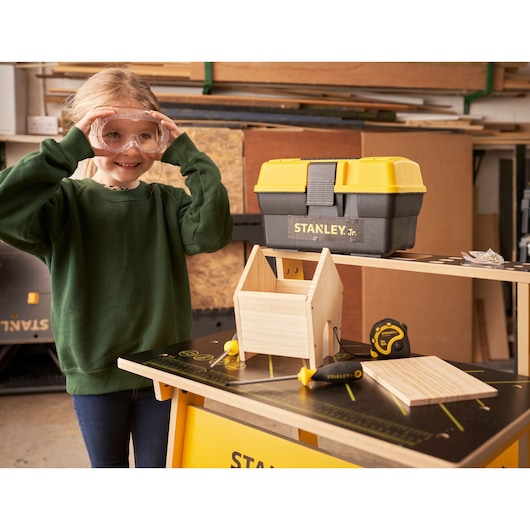 STANLEY K020-SY toolbox, screwdriver, and wooden project kit on a workbench in a workshop setting.