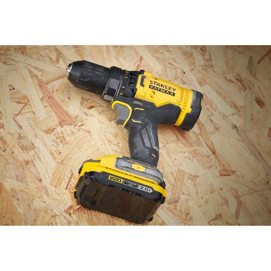 STANLEY SFMCD700D2S cordless drill driver with yellow and black design on wooden surface, side angle.