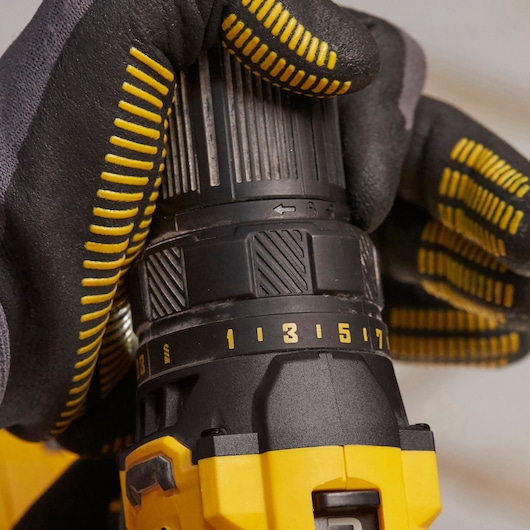 Photo of STANLEY SFMCD700D2S drill close-up, showing torque settings in use with gloved hand.