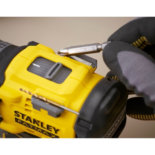 STANLEY SFMCD726B drill close-up with bit holder, yellow and black, gloved hand holding bit.