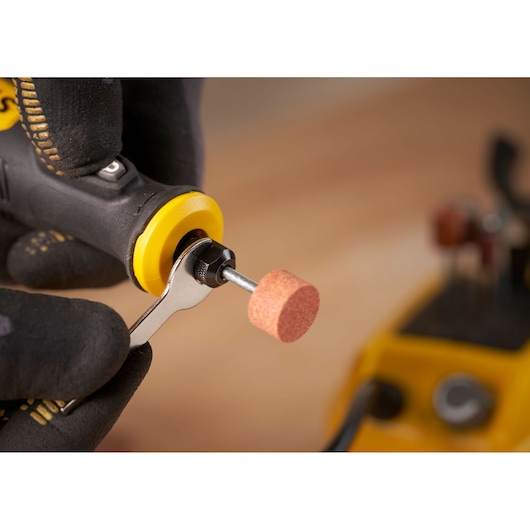 STANLEY SFMCE030B rotary tool with grinding attachment, close-up showing accessory change with wrench.