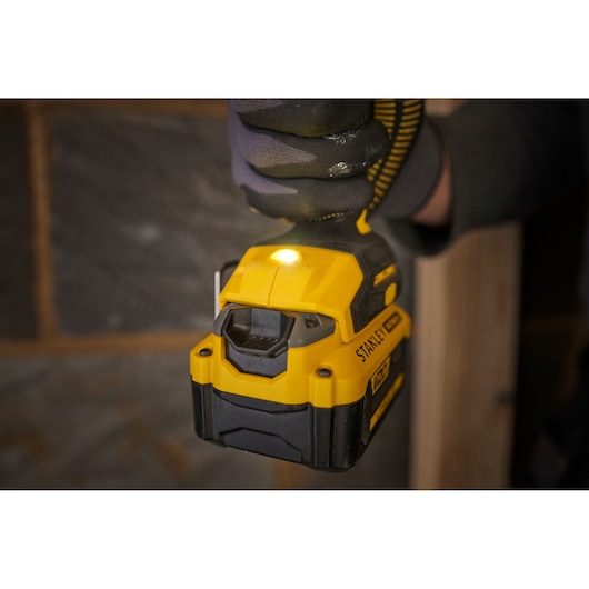 Photo of STANLEY SFMCF811B-XJ cordless impact driver in use, yellow and black, close-up view.
