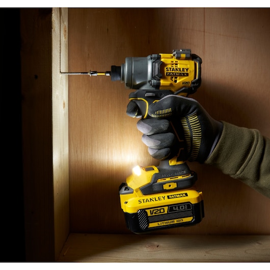 STANLEY SFMCF830B impact driver being used on wood, close-up with gloved hand, yellow and black design.