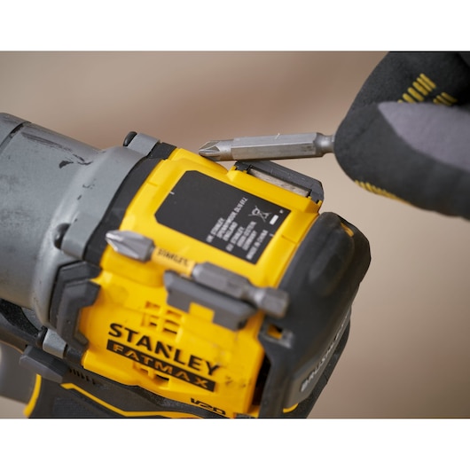 STANLEY SFMCF830B impact driver close-up with bit storage and gloved hand inserting bit.