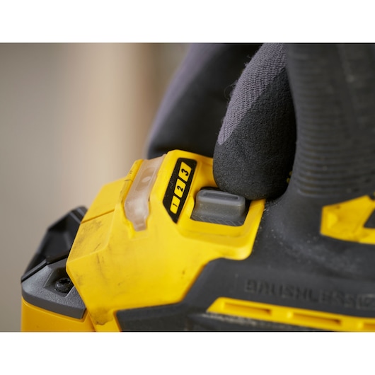 STANLEY SFMCF830B cordless power tool speed selector close-up, yellow and black with gloved hand.