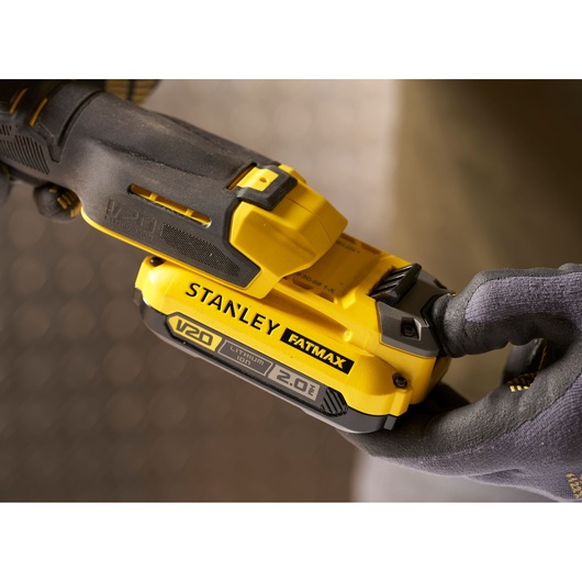 Photo of STANLEY FATMAX V20 SFMCF930B cordless tool, close-up showing battery pack and gloved hand.