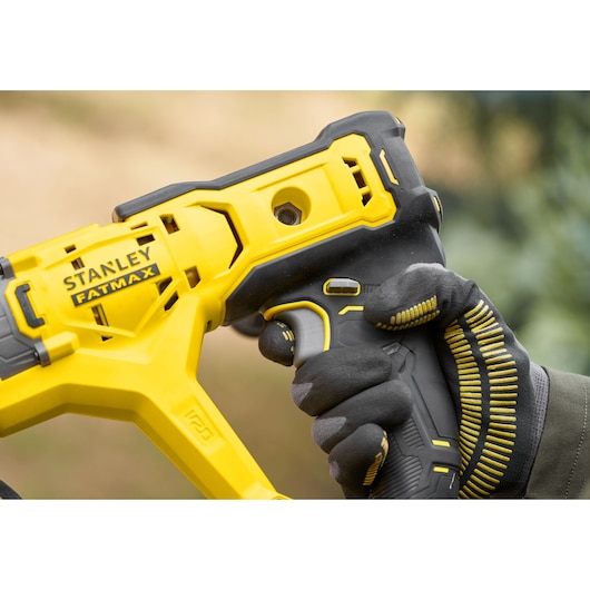 Photo of STANLEY SFMCGA75B FATMAX cordless tool handle held by gloved hand, yellow and black design.