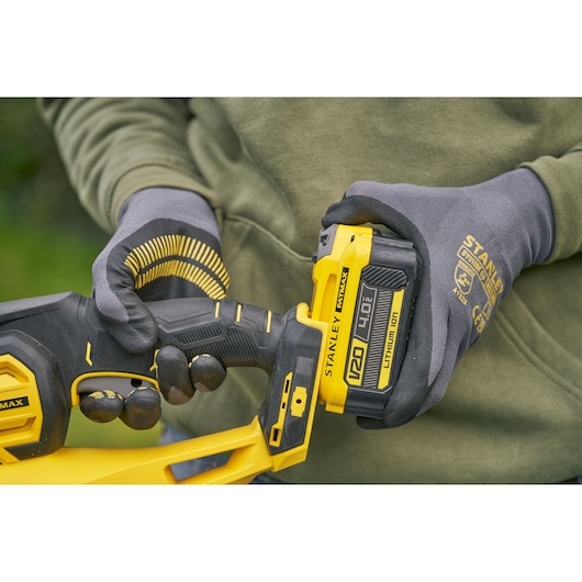Photo of STANLEY SFMCHT655M1 cordless tool with 20V 4.0Ah lithium ion battery in use, close-up view.
