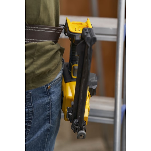 STANLEY SFMCN616B nail gun attached to a tool belt, close-up side view.