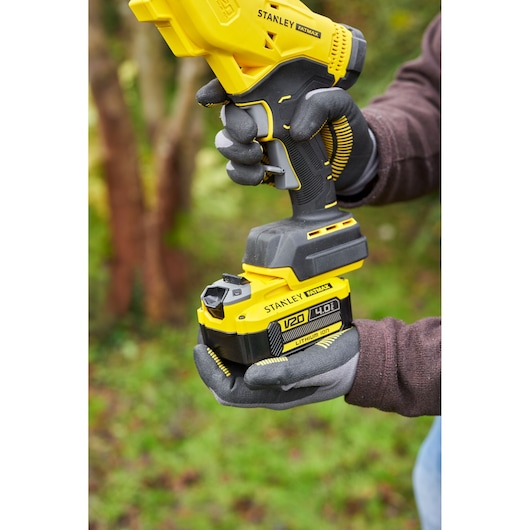 STANLEY SFMCPP32B cordless tool with V20 4.0Ah yellow lithium-ion battery, outdoor angle.