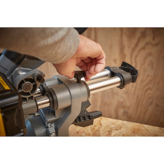 STANLEY SFMCS701B miter saw close-up showing adjustment knob being turned.