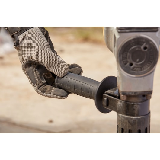 Photo of STANLEY SFMEH220K-QS rotary hammer handle held by gloved hand, close-up view.